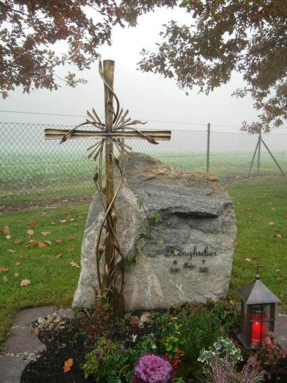 Bronzekreuz in Niederbayern - mit Ranken und Grablampe neben Naturstein