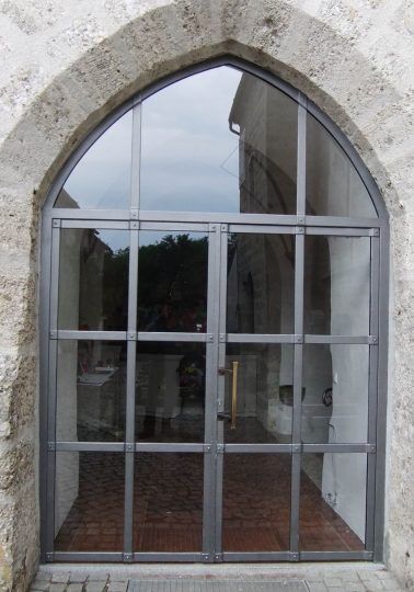 Kirchentor geschmiedet, zweiflügelig mit Spitzbogen und Glasfüllung 
