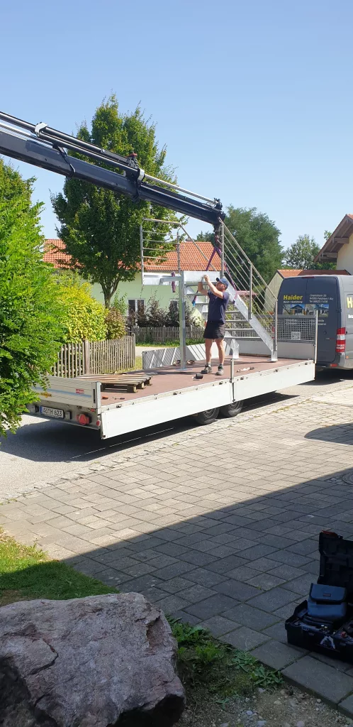 Eine verzinkte Aussentreppe wird mit einem Autokran montiert.