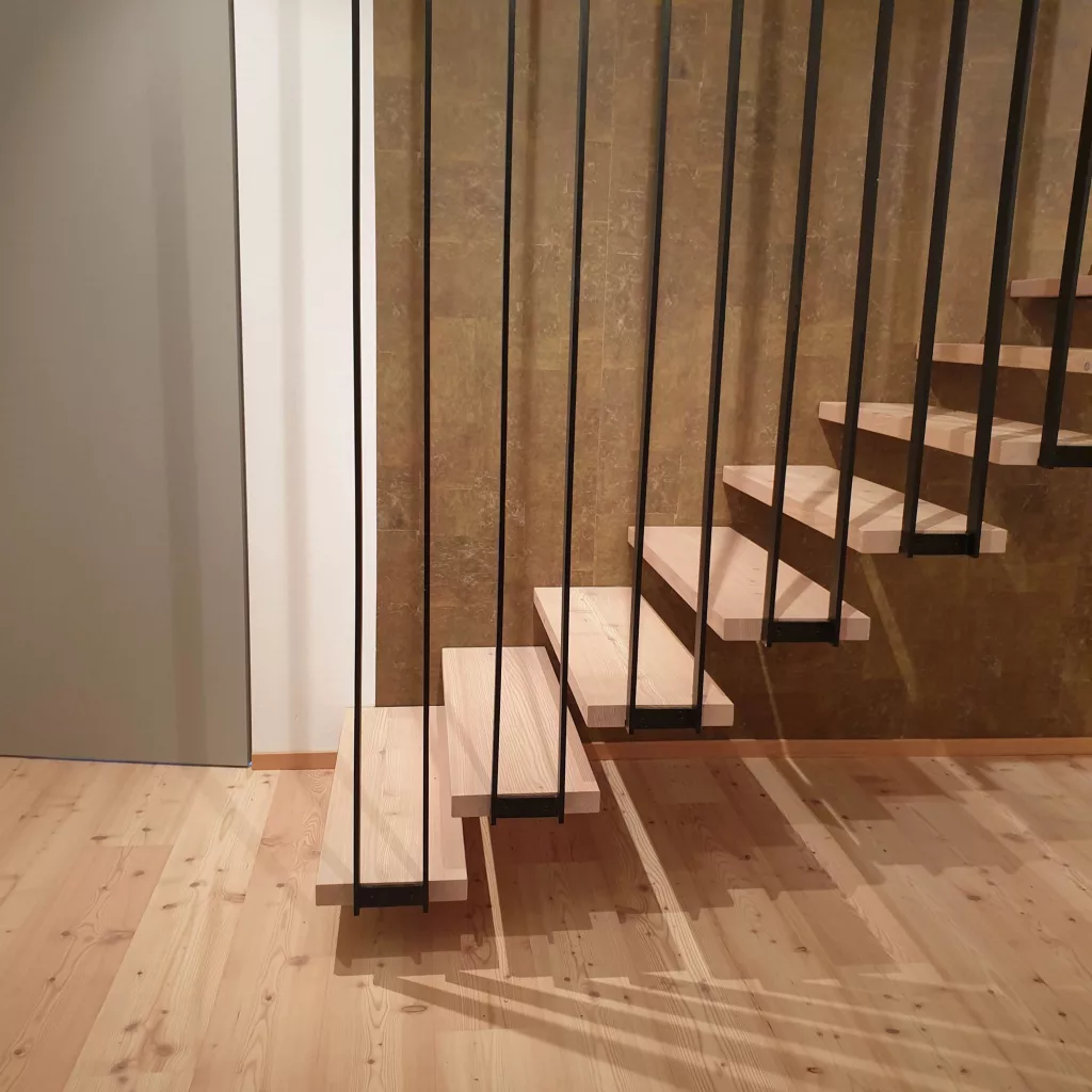 Geländerstäbe und Auflager für die Treppenstufen in Lärche.
Wandseitige Befestigung wie bei einer Kragarmtreppe.