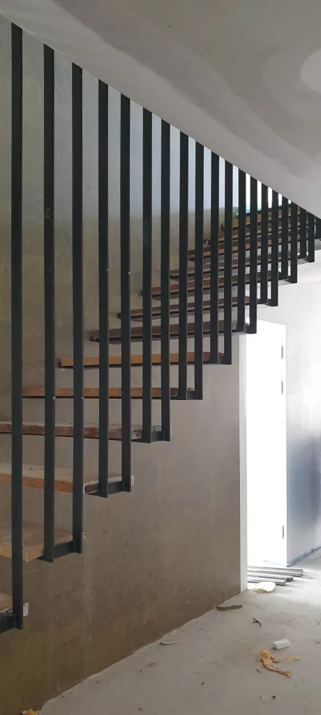 Innentreppe mit Baustufen. Mattschwarz lackierte Treppe in Traunstein in Oberbayern.