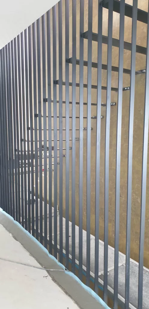 Harfentreppe Traunstein - mattschwarze Metallkonstruktion mit Sufenauflagern und durchgehenden Geländerstäben zur Befestigung der Treppenstufen.