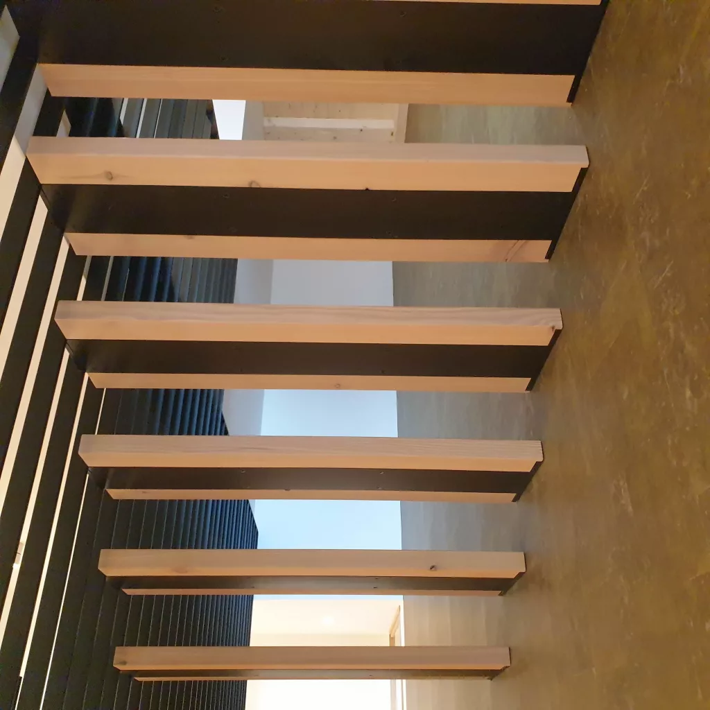 Metalltreppe mit eingefrästen Treppenstufen und Wandbefestigung.